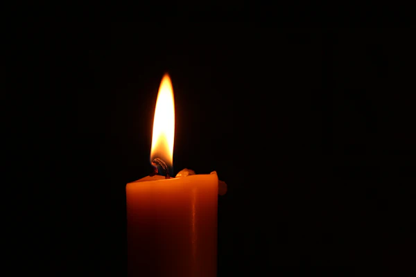 Vela encendida en la penumbra, símbolo de la luz del conocimiento