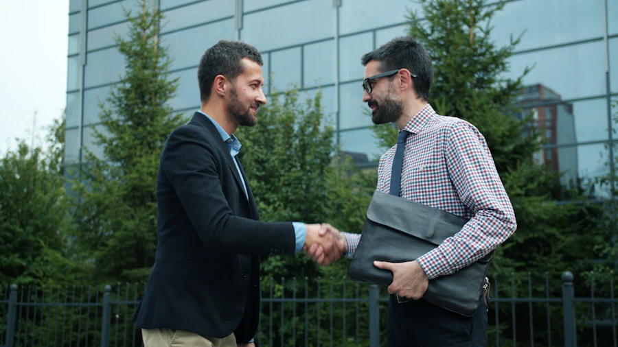 Dos personas estrechando la mano al aire libre en señal de acuerdo y confianza